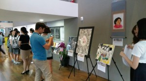 'Justice for Comfort Women' members' paintings are exhibited at the lobby of the National Theater. People taking pictures.